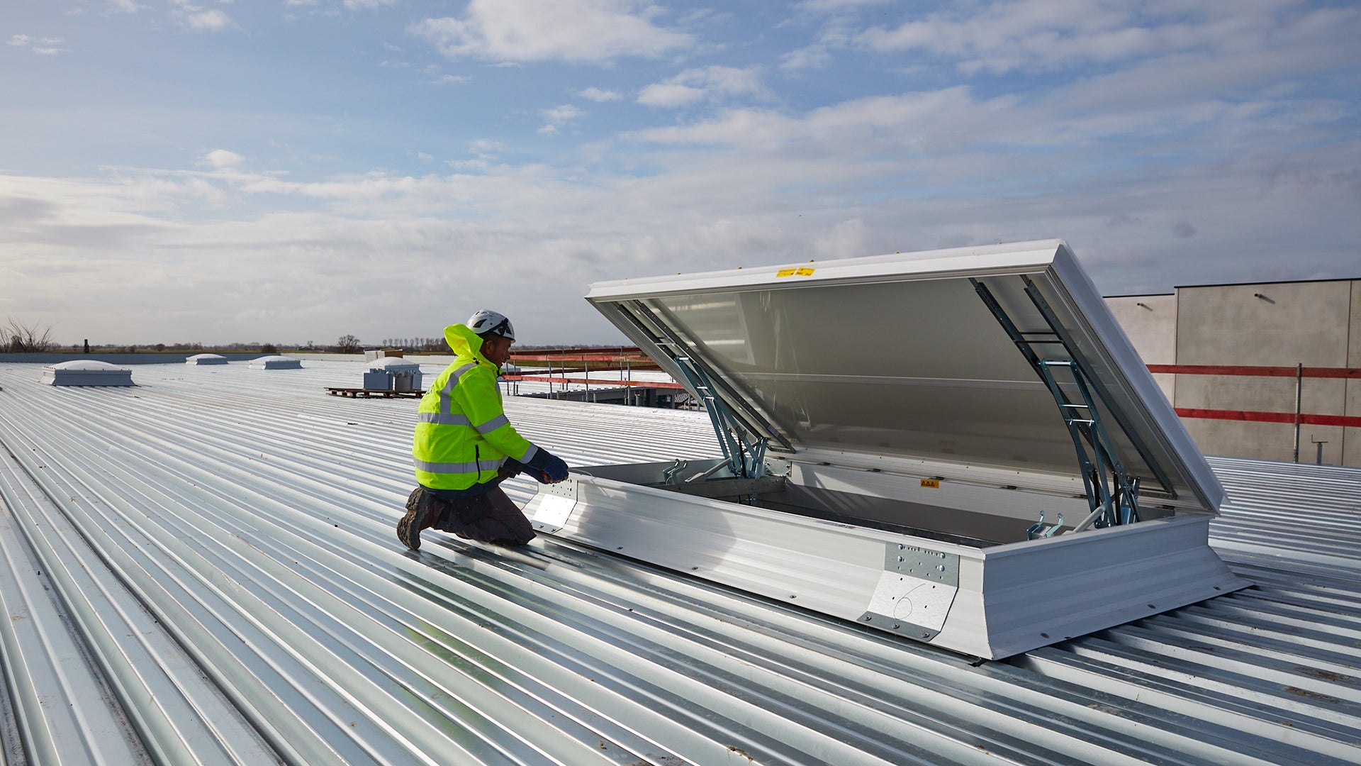 Gecertificeerde Skylux technicus controleert een RWA-systeem op een plat dak