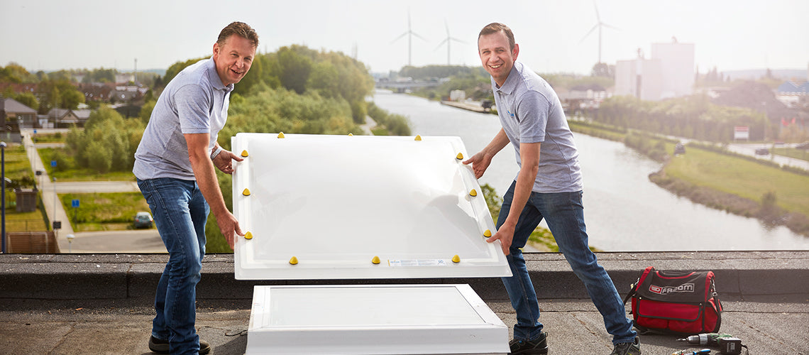 Twee Skylux-professionals plaatsen een platdakraam op een renovatieproject in België